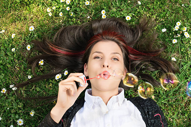 istock Young girl blowing soap bubbles 472034458