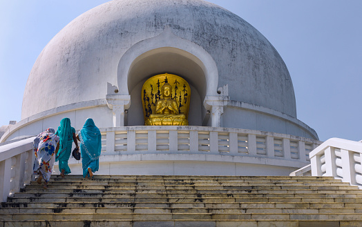 Patna, India - October 14, 2011: Women is saris visit the Buddhist World Peace Pagoda on a bright sunny day.