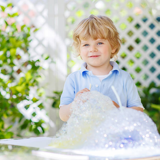 istock Happy little boy making experiment with colorful water and soap 472035442