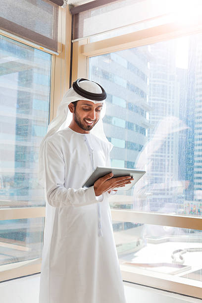 istock Arab businessman using digital tablet in Dubai office. 472035842
