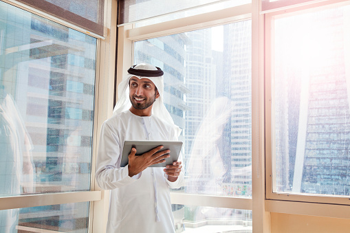 Hombre de negocios árabe utilizando tableta digital en Dubai oficina. photo