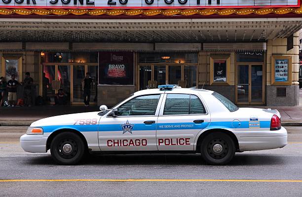 Chicago, United States - June 26, 2013: People walk past police car on June 26, 2013 in Chicago. Chicago Police Department is one of oldest police forces in the world, dating back to 1837.