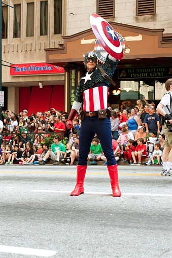 Atlanta, GA, USA - August 31, 2013:  Super hero Captain America raises his shield to salute the crowd at the annual Dragon Con parade on Peachtree Street.