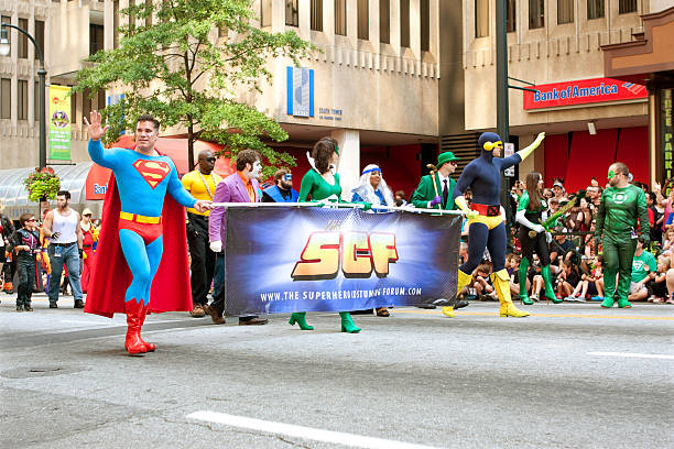 Superman Walks In Atlanta Dragon Con Parade Atlanta, GA, USA - August 31, 2013:  Superman character carries banner while walking down Peachtree Street in the annual Dragon Con parade. superman named work stock pictures, royalty-free photos & images