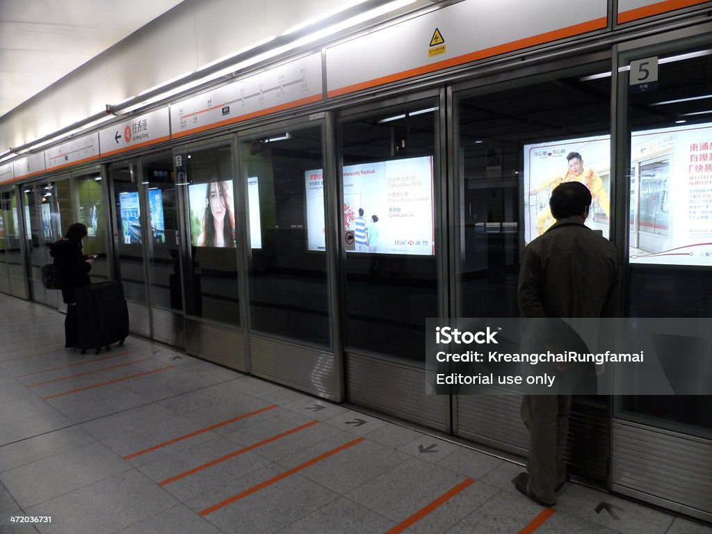 Transportation system in Hong Kong Hong Kong, China – December 2, 2012: Passengers waiting at a platform for a Mass Transit Rail (MTR) railway train at a subway station in Hong Kong. Subway system in Hong Kong is efficient, and helps to relieve traffic problems in Hong Kong.  Hong Kong is one of the most densely populated cities in the world. Asia Stock Photo