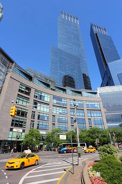 Columbus Circle New York City, United States - July 6, 2013: Taxi drives at Columbus Circle on July 6, 2013 in New York. Columbus Circle with famous Time Warner Center skyscrapers completed in 2003 is one of New York landmarks. time warner center columbus circle pictures stock pictures, royalty-free photos & images