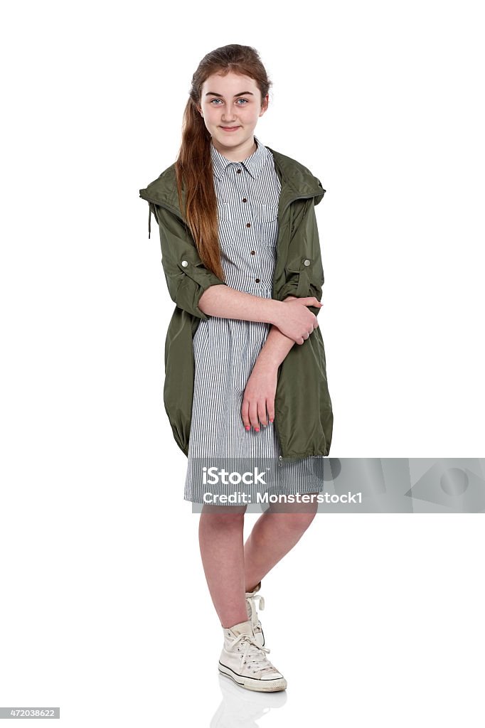 Cute young girl looking at camera Studio shot of cute young girl looking at camera while standing over white background Girls Stock Photo