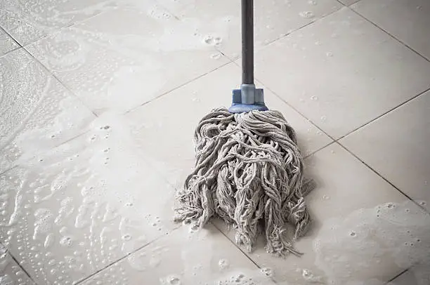 Floor cleaning with mob and cleanser foam.