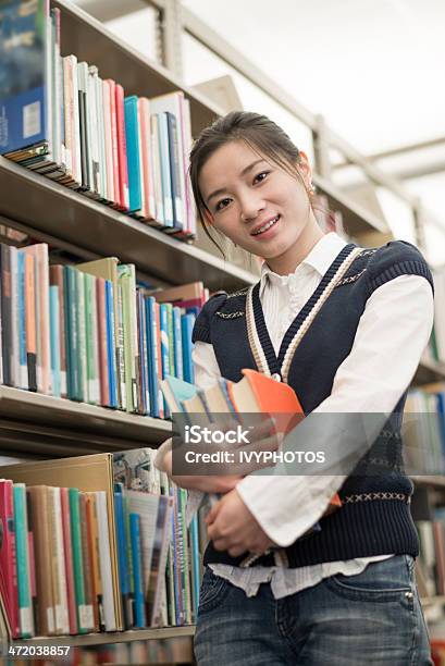 Estudante Segurando Livros Seguinte Para Estante De Livro - Fotografias de stock e mais imagens de Adulto