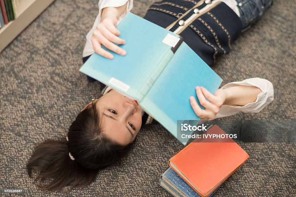 Étudiant avec des livres Allongez-vous sur le dos sur un tapis - Photo de Adulte libre de droits