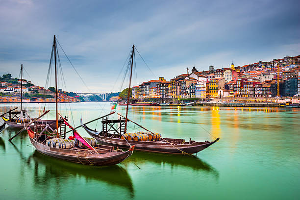 Beautiful depiction of boats at Porto Portugal Porto, Portugal old town cityscape on the Douro River with traditional Rabelo boats. portugal photos stock pictures, royalty-free photos & images