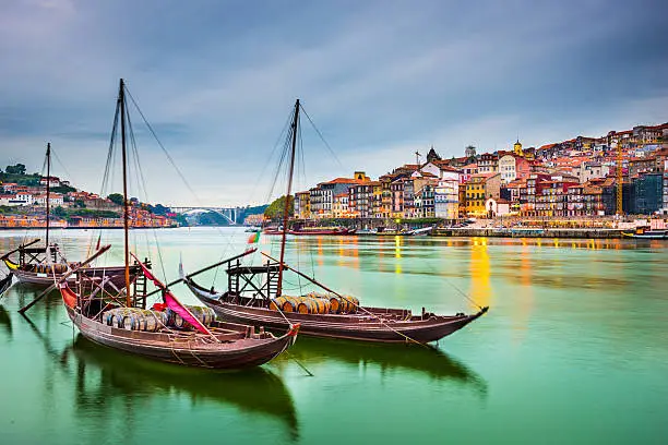 Porto, Portugal old town cityscape on the Douro River with traditional Rabelo boats.