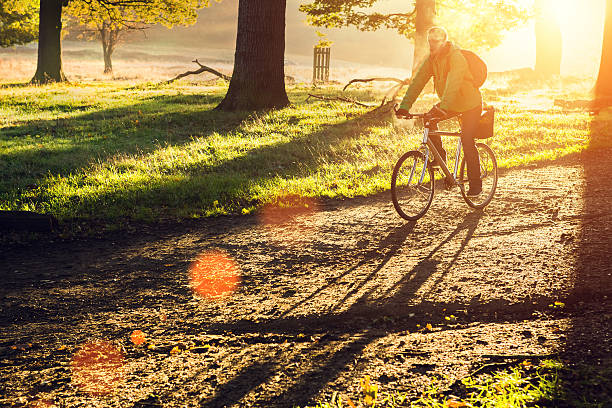 young man cycling in the morning young man cycling in Richmond Park, London in the morning richmond park stock pictures, royalty-free photos & images