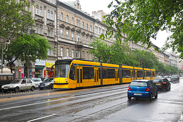 Budapest, Hungary - May 7, 2012: In pouring rain, the driver of Budapest Route 6 Tram 2029 has a trouble-free run along the middle of Teréz körút (Nagykörút or Grand Boulevard), while surrounded by slow-moving or stationery traffic.   Built by Siemens, the six-section Combino Supra NF 12B is the world’s longest tram at 54m (177 feet) and has the capacity to carry 350 passengers.