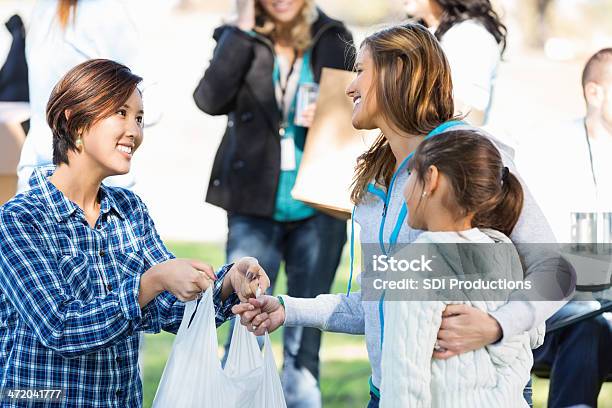 Mom And Young Daughter Accepting Donations At Food Clothing Drive Stock Photo - Download Image Now