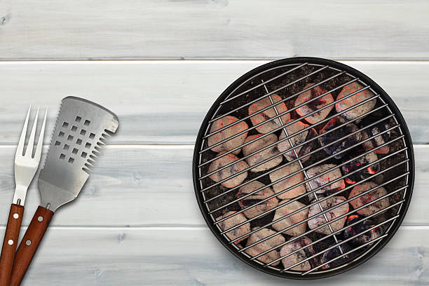 istock Grill with Glowing Briquettes and BBQ Utensils 472042308