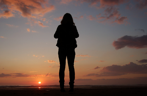 Woman watching the sunset on the IJmuiden beach