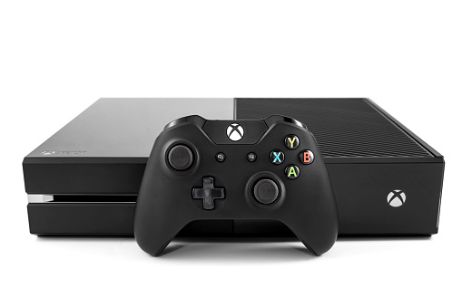 Nashville, Tennessee, USA - November, 30th 2013: A photograph of the new Xbox One video game console, sold by Microsoft, with the Xbox controller leaning against the front. Shot against a white background in Nashville TN.