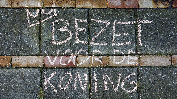 Occupy for the king written in Dutch with a crown on the sidewalk for King's day