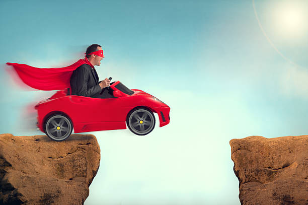 istock man in a car jumping a ravine 472045786