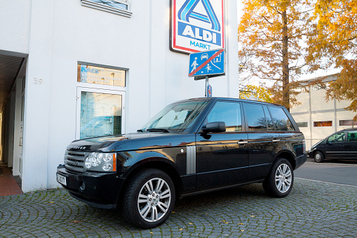 Essen, Germany - November, 16th 2013: Range Rover Discovery is standing in pedestrian zone in front of road sign and building with banner of Aldi Nord.