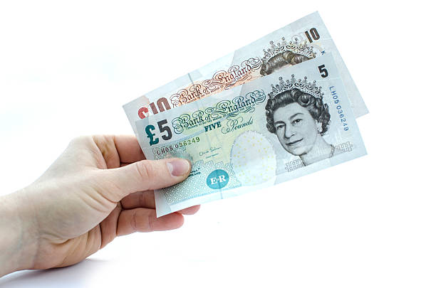 держит 15 фунтов - pound symbol ten pound note british currency paper currency стоковые фото и изображения