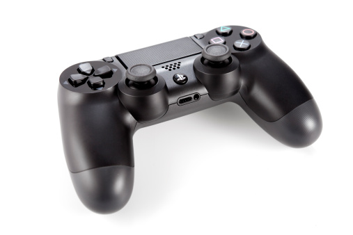 Zgierz, Poland - November 29, 2013: Close-up of a joypad for Play station 4 on white background. The PlayStation 4 is a video game console produced by Sony Computer Entertainment.