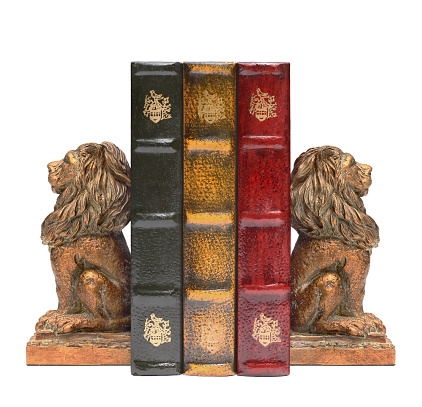 Lion Bookends and Antique Old Books Isolated on White.
