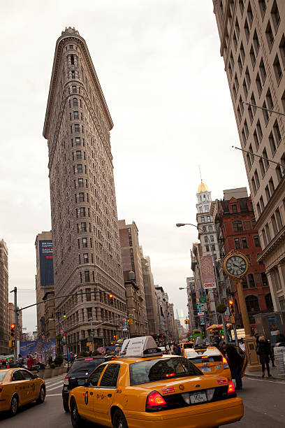 Flatiron building in New York City New York City, USA - November 23, 2013: Flatiron Building with traffic at the afternoon. It is located at 175 Fifth Avenue in the borough of Manhattan, New York City. new york state license plate stock pictures, royalty-free photos & images