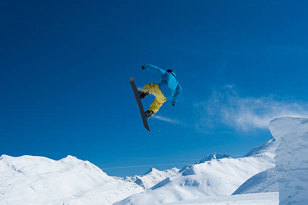 istock Snowboarder in mid-air against the blue sky 472047263