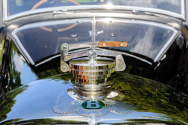 Classic Bentley Detail Apeldoorn, The Netherlands - September 5, 2010: Bentley emblem on the hood of a 1920s Bentley Eight LeMans Special. The car is on display in the park of Palace Het Loo during a summer day. silver chrome number 8 stock pictures, royalty-free photos & images