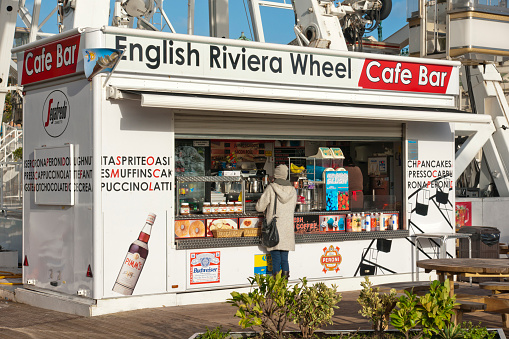 Torquay,England - November 2, 2013: A lady is buying something at this kiosk and cafe bar by the big wheel at Torquay in south Devon