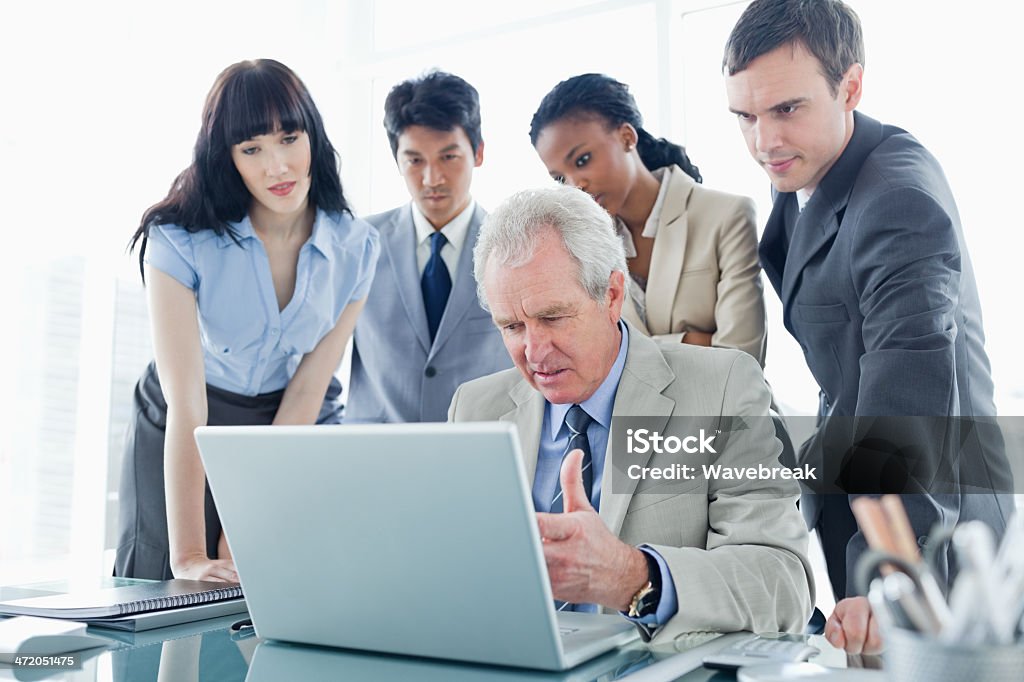 Business team concentra sul computer, ascoltando ° - Foto stock royalty-free di 60-69 anni