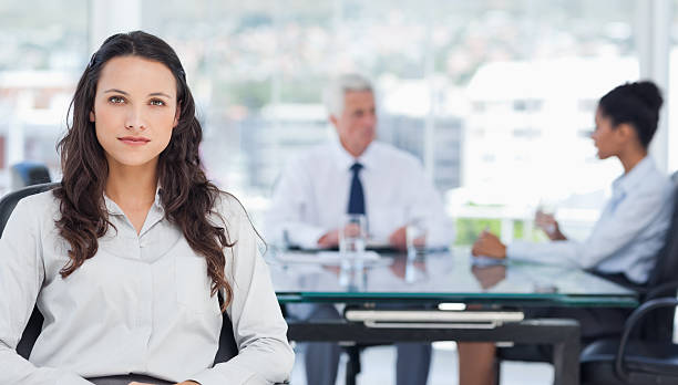 istock Saleswoman with meeting behind her 472051703