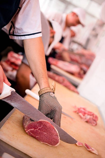 Close-up of a butcher slicing a piece of meat