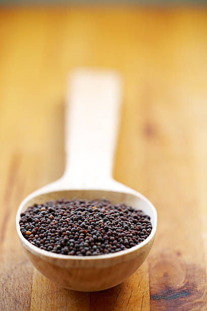 istock Brown mustard seeds in wooden spoon 472053097