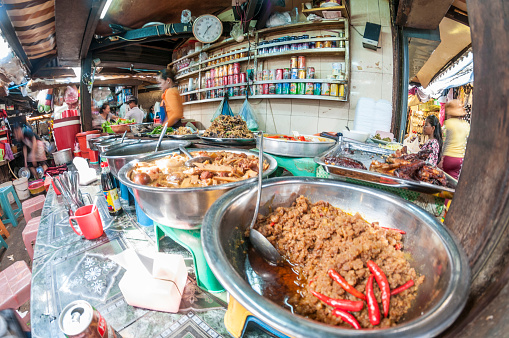 Phnom Penh, Сambodia - December 4, 2013: Food stall with vendor and customers in Phsa Chas Market sometimes called the Old Market in the Cambodian capital city Phnom Penh