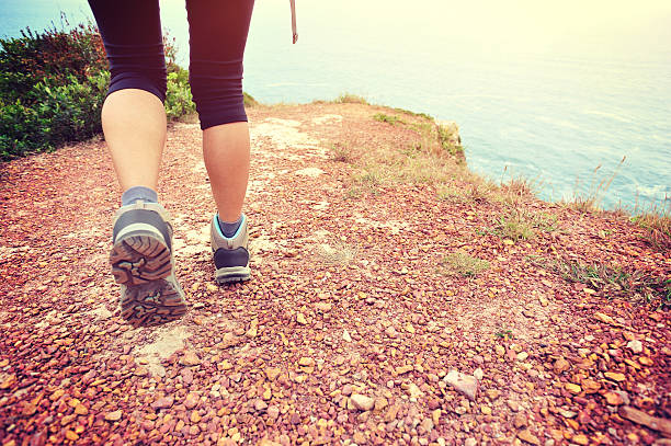 istock woman hiker hiking on seaside trail 472053864