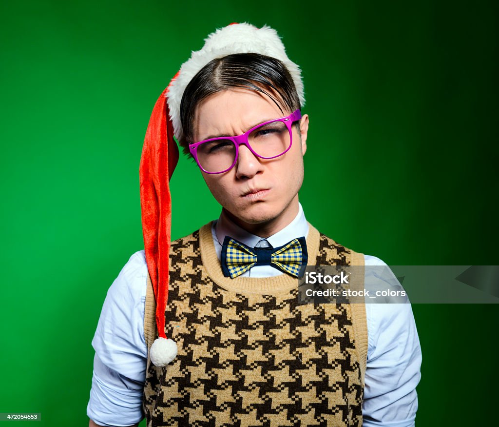 nerd frowning funny nerd frowning with negative expression wearing santa hat. 20-29 Years Stock Photo