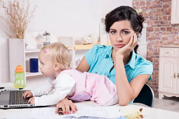 Young business woman with laptop and her baby girl