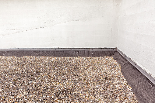 flat roof filled with boulders on the roofing
