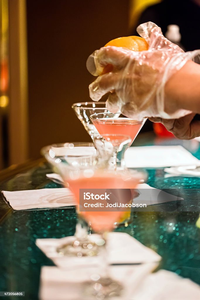 Bartender making specialty alcoholic martini at bar A bartender makes several specialty alcoholic martinis at the bar.  RM Adult Stock Photo