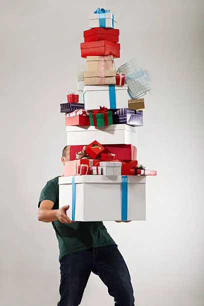 Photo of Man Carrying Stack of Gift Box