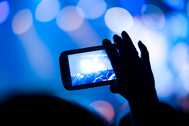 istock Spectator filming concert with his cell phone 472057493
