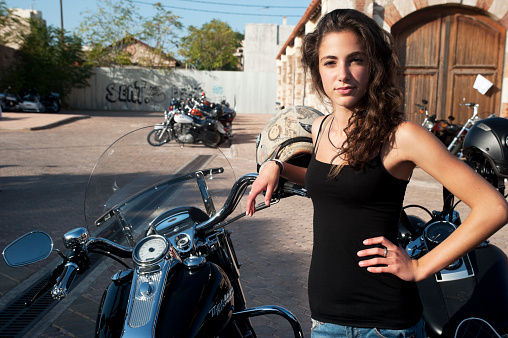 Athens, Greece - October 13, 2013: Young female stands by parked motorcycles in a Harley Davidson event