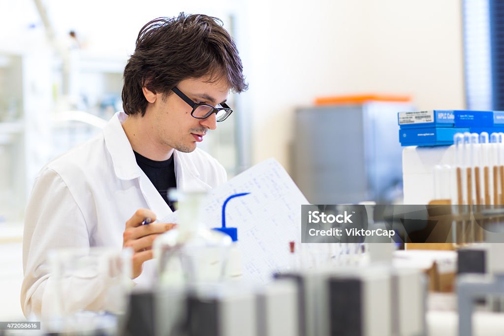 Male researcher carrying out scientific research Male researcher carrying out scientific research in a modern high-tech lab (shallow DOF; color toned image) 2015 Stock Photo