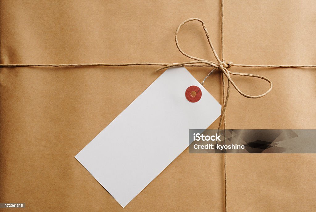 Close -up of ブラウンくるまるパッケージには、空の紙タグ - ちょう結びのロイヤリティフリーストックフォト