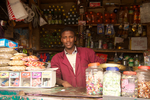 Addis Ababa,Ethiopia-July 28, 2013 : The man who is owner of the shop is standing behind the counter in the small shop at Chad Street in Addis Ababa.
