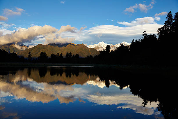 Lake Matheson on New Zealand's South Island, with the Southern Alps reflected in its mirror-like surface.