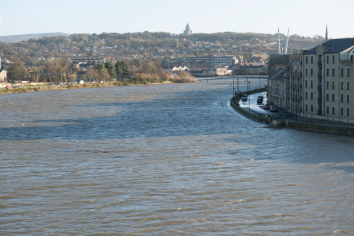 Lancaster, UK - December 5, 2013: View of one of the highest tides of 2013 with strong gale force winds creating a storm surge at the River Lune, St. George's Quay, Lancaster, Lancashire. The recently constructed flood defence wall held back the water from Flooding St. Georges Quay.